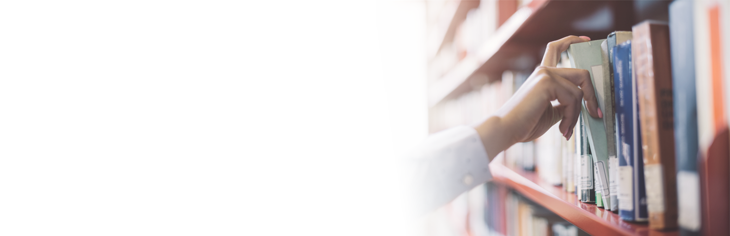 Woman pulling a book of a shelf in a library