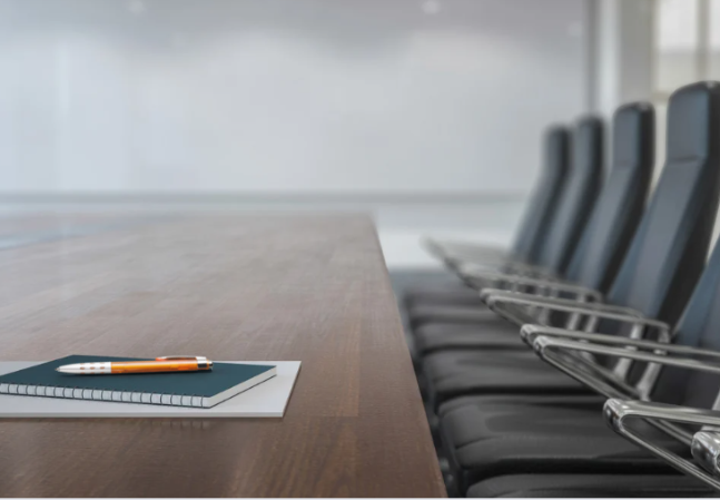 Empty board room with a notebook and pen on the table