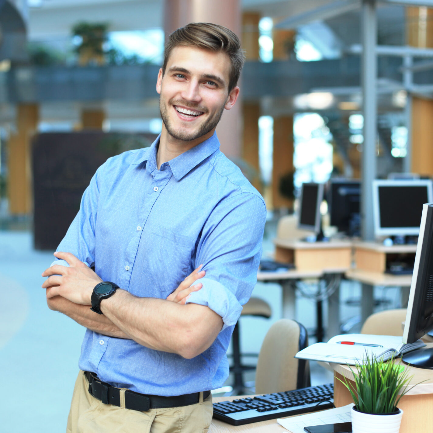 Young man posing confident and positive in professional workplace office with space